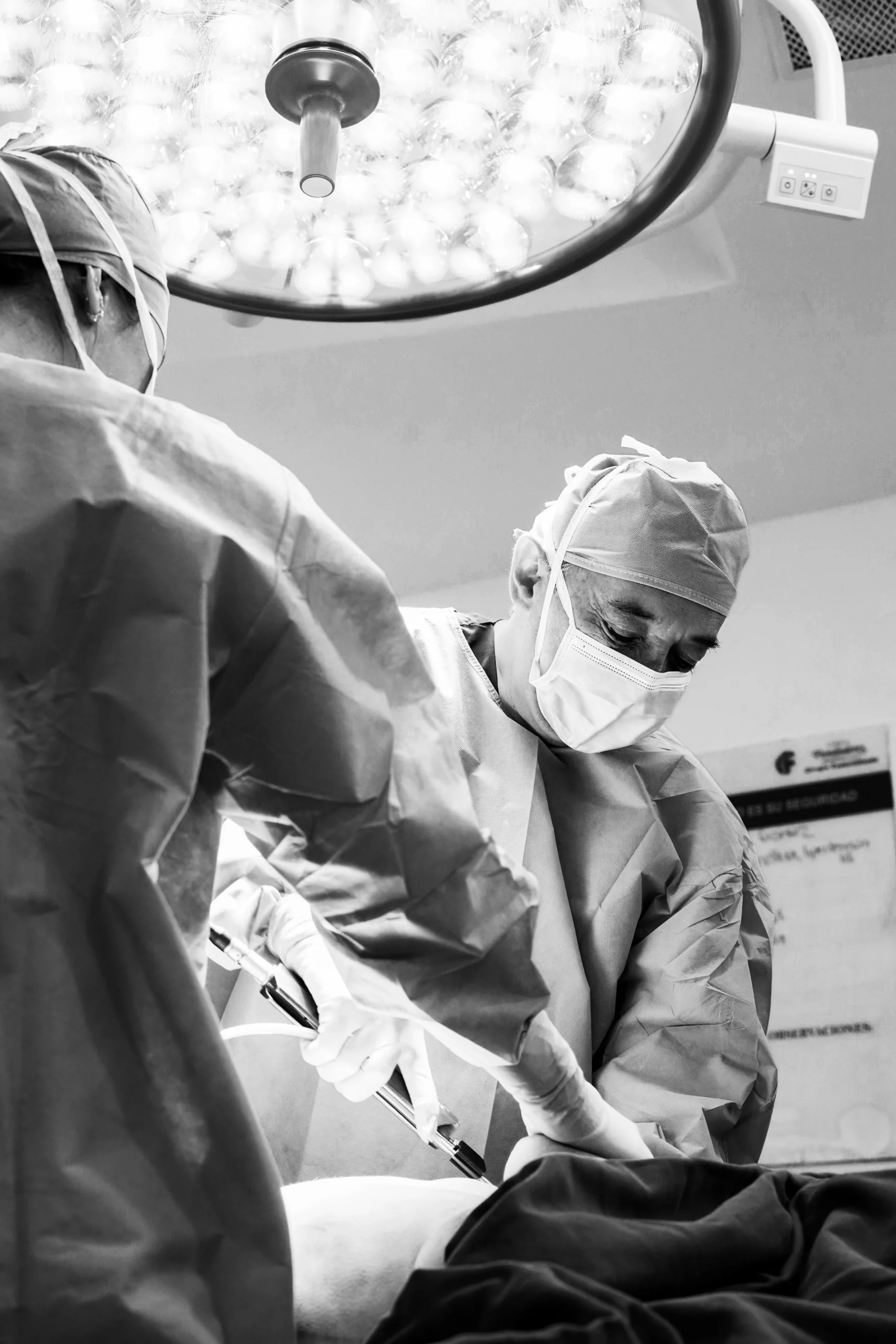 Cirujano plástico realizando procedimiento estético en quirófano – fotografía documental de salud y precisión visual por Suma Estudios