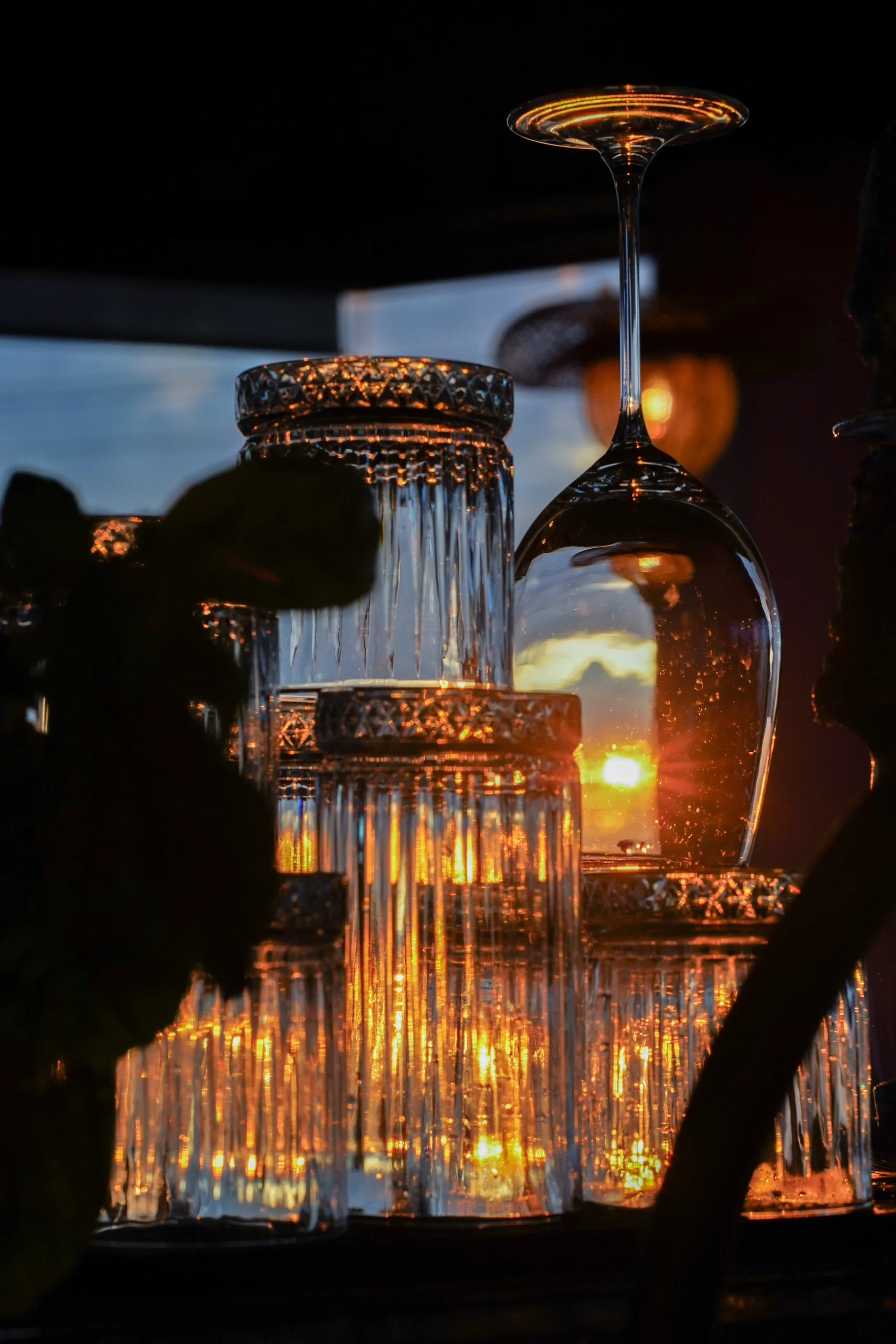 Copas y vasos de cristal reflejando la luz dorada del atardecer en Elena Adentro, restaurante en Filandia, Quindío – fotografía de ambientación por Suma Estudios