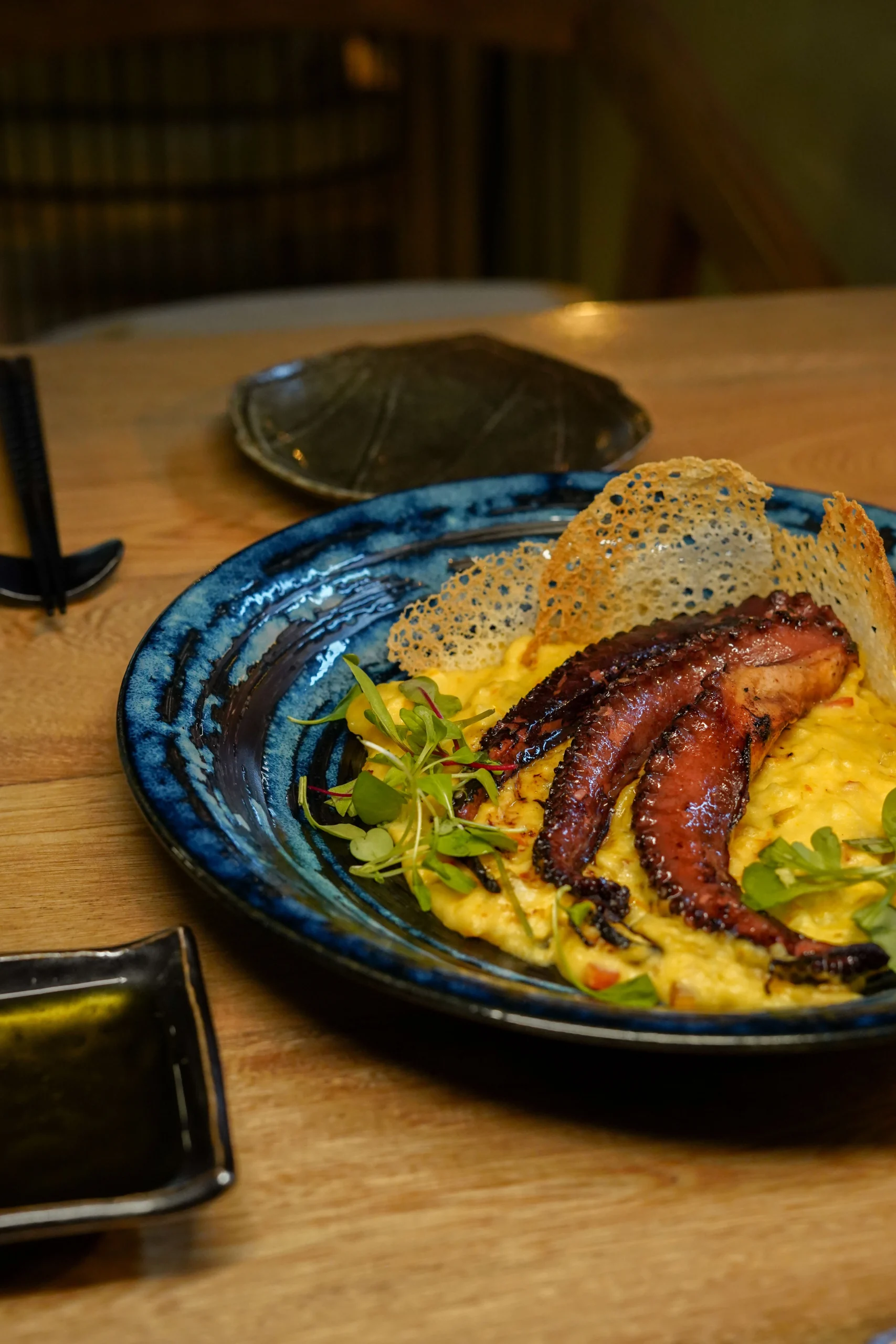 Plato de pulpo a la parrilla sobre puré cremoso y crujiente de parmesano en restaurante Zakani – fotografía gastronómica por Suma Estudios</p>
<p>