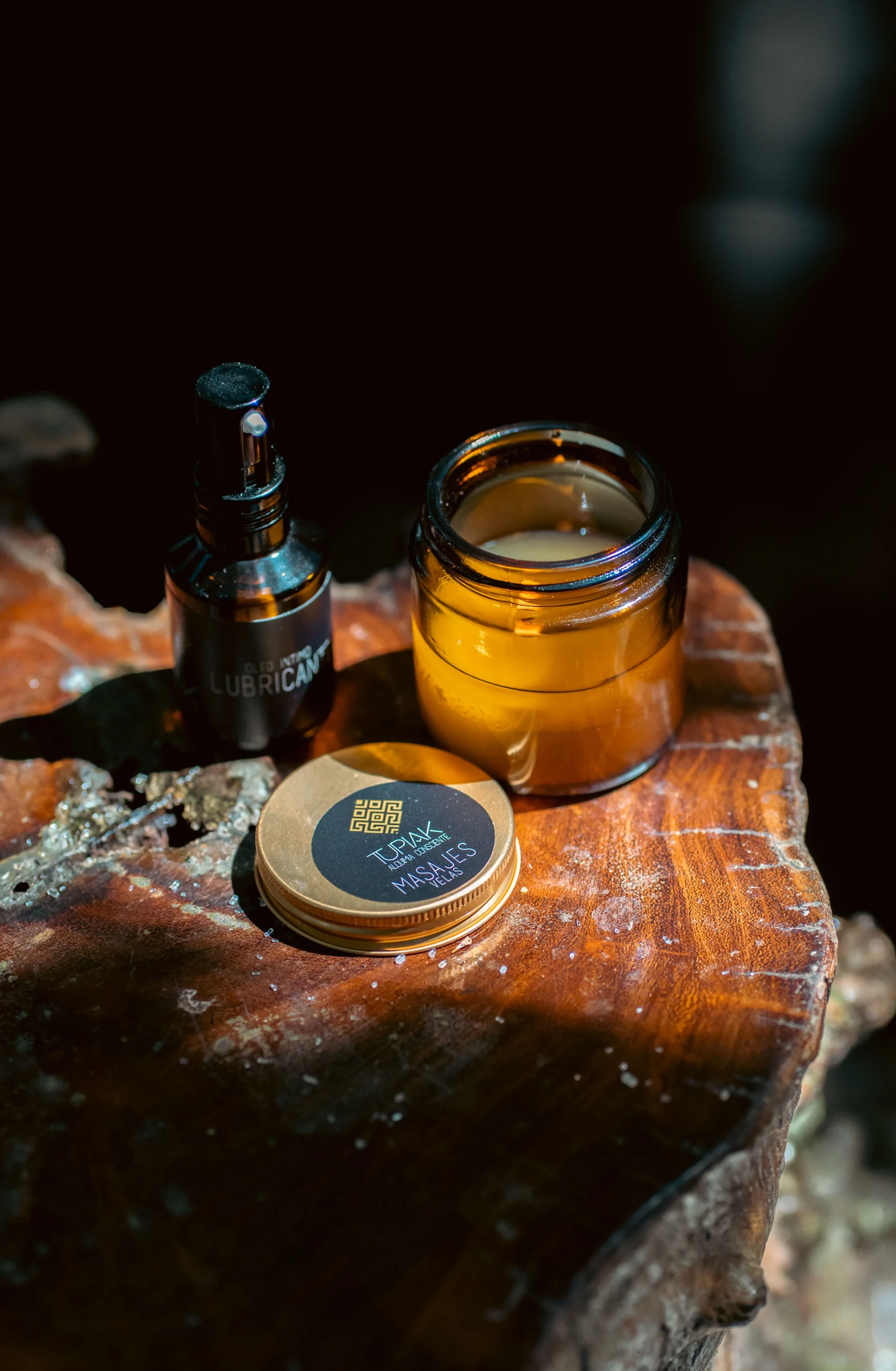 Frascos ámbar de bálsamo y lubricante sobre madera iluminados por luz natural – fotografía de productos de cuidado corporal por Suma Estudios