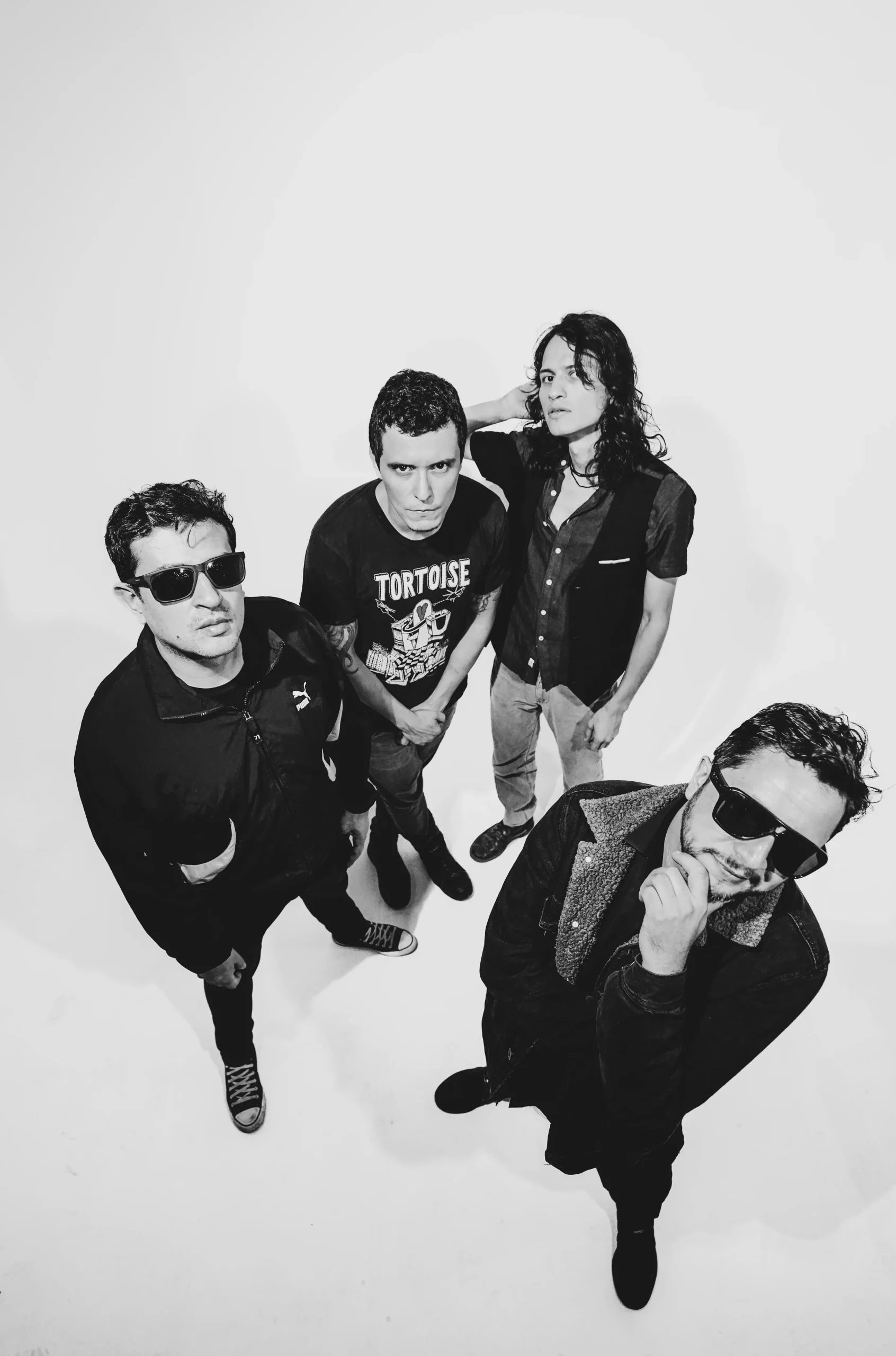 Retrato de la banda Astrolícos en estudio con fondo blanco – fotografía en blanco y negro por Suma Estudios
